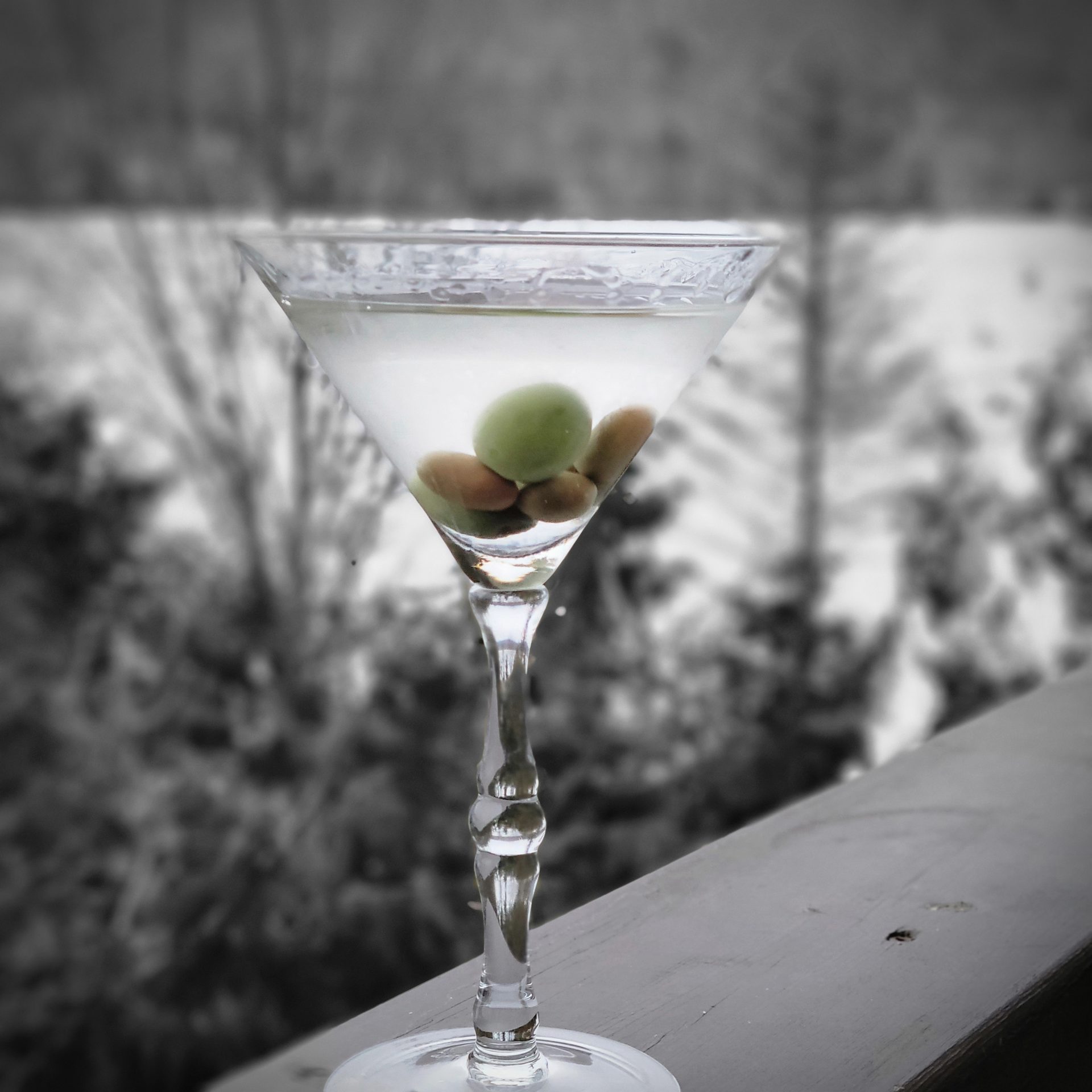 Olive martini with lake view at sunset
